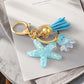 Keychain with starfish and sea turtle charm on a marble surface