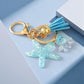 Keychain with starfish charm, tassel, and gold clasp on a light blue background