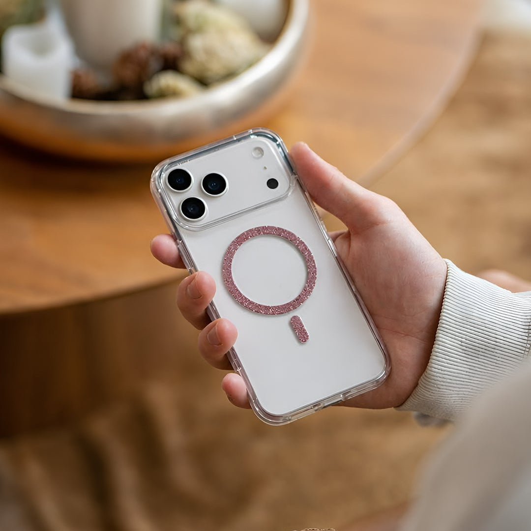 Person holding a phone with a clear case featuring a brand logo on a wooden table.
